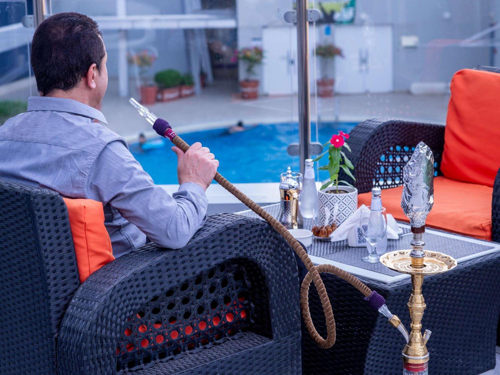 Novotel Jazan Exterior photo A man smoking a hookah